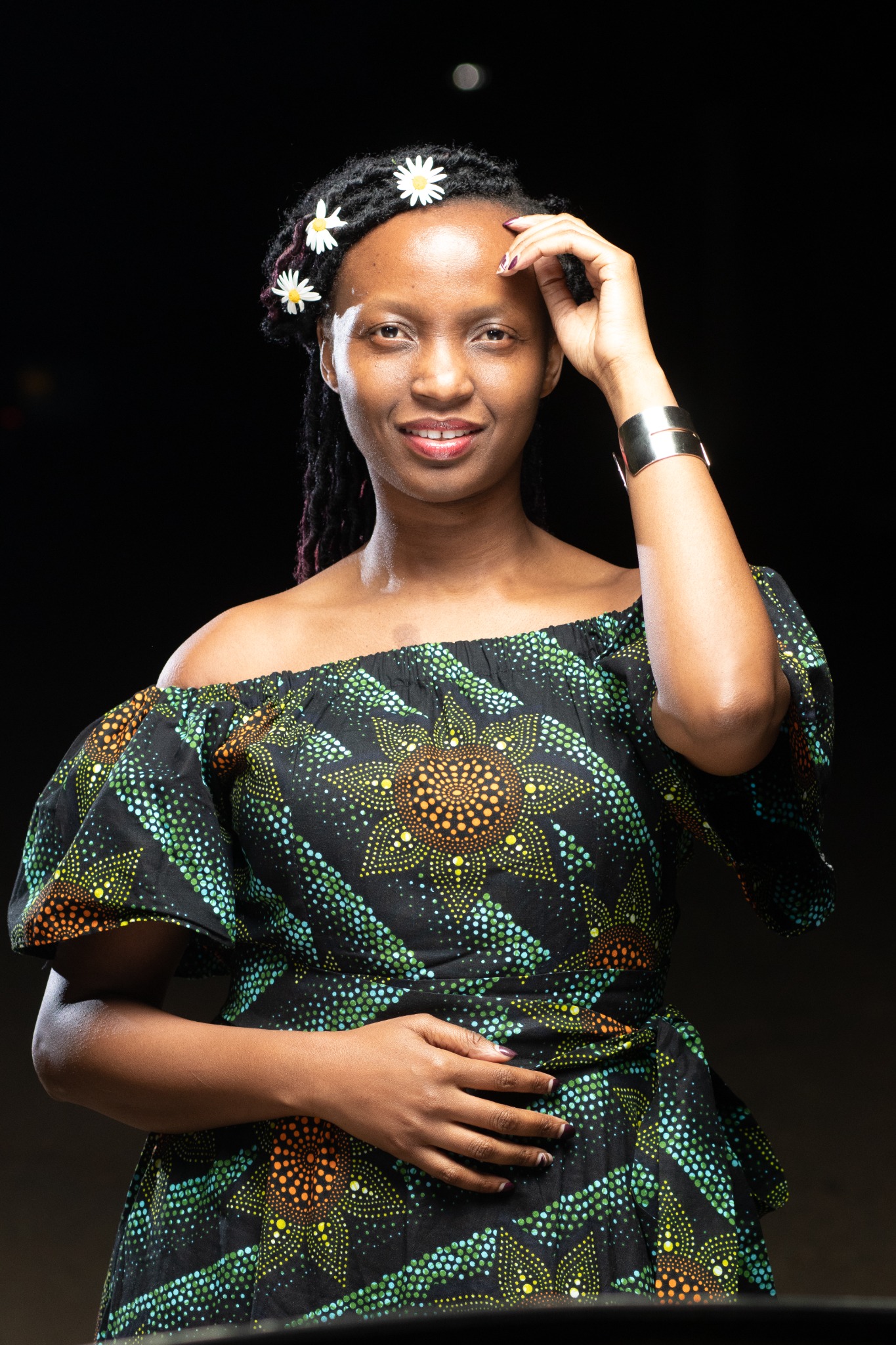 Bilha in a patterned dress with flowers in her hair